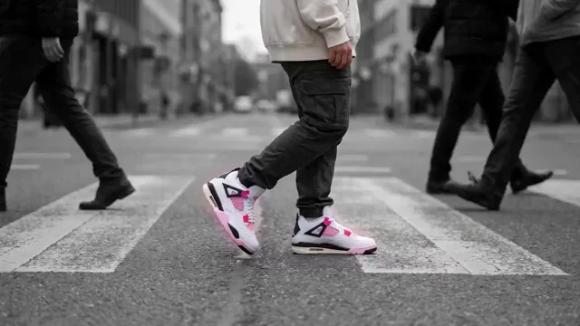 A pedestrian crossing in black and white, the only colour a pair of glowing pink Air Jordan 4s